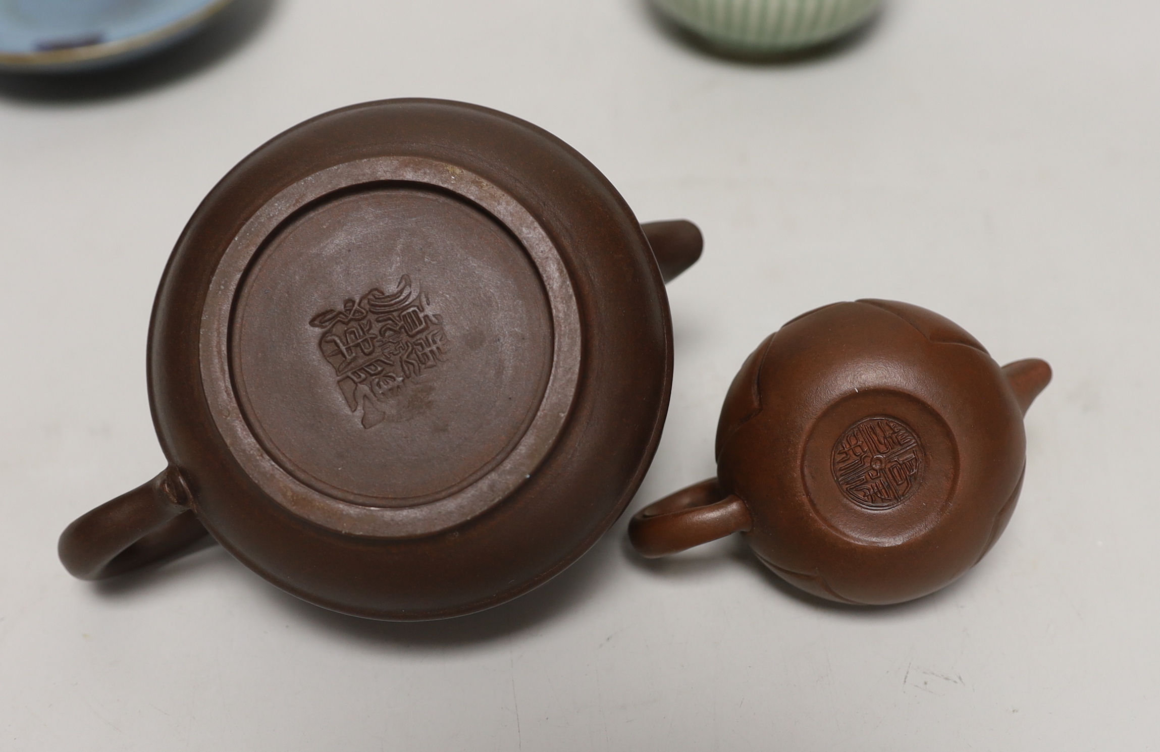 Two Yixing teapots, a celadon glazed circular box and Jun type saucer, 12cm diameter